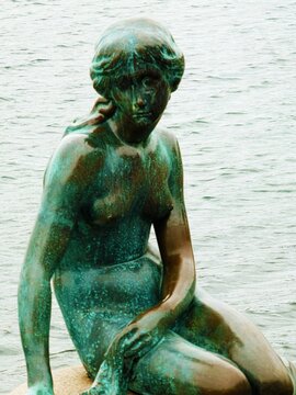 Copenhagen, Denmark - Close up of the Little Mermaid statue from 1913 on a rock at the entrance of Copenhagen harbor, symbol of the Danish capital, inspired by the Christian Andersen fairy tale.