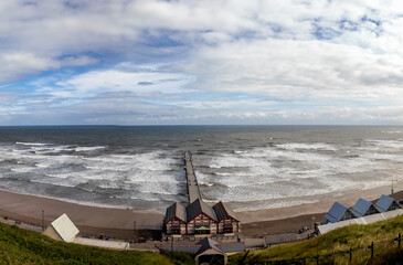 Looking down at waves crashing onto the beach at Saltburn-by-the-Sea in North Yorkshire, UK - obrazy, fototapety, plakaty