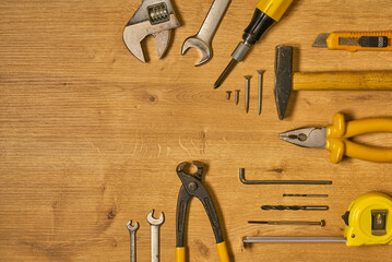 Hand tools, construction tools on a wooden surface.