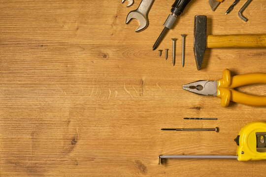 Hand tools, construction tools on a wooden surface.