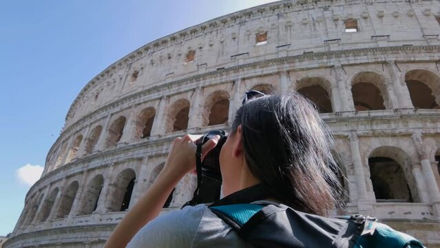 A tourist taking pictures of the Colosseum while visiting Rome