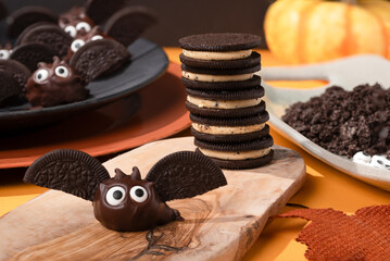 Making chocolate covered cookie bats with big eyes for the Halloween party.
