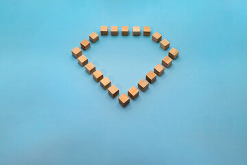 ダイヤモンドの形をした立体的なウッドキューブを下からみた水色の背景のフレーム