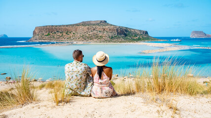 Crete Greece, Balos lagoon on Crete island, Greece. Tourists relax at the crystal clear ocean of Balos Beach. Greece, a couple of men, and a woman visit the beach during a vacation in Greece