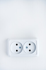 White double electrical outlet on a white background. Eurozette close-up. Electrical appliance.