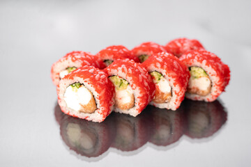 Traditional delicious sushi roll California on a white background with reflection. Sushi roll with rice, cream cheese, salmon. Sushi menu. Japanese restaurant. Asian Seafood