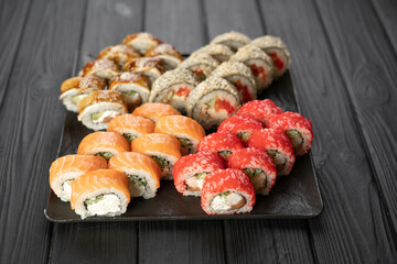 Sushi set on black background, top view. Traditional Japanese seafood. Delicious roll. Food delivery service.