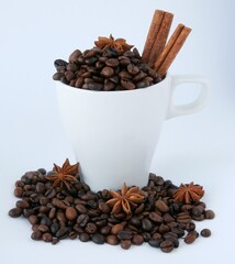 Coffee beans in a cup with cinnamon and star anise