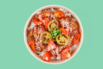 rice with tomatoes, peppers and fried meat and hapanero peppers on a green background, studio shot