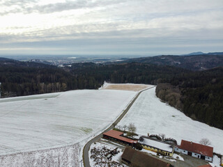 winter with agricultural fields covered with snow on a cloudy day