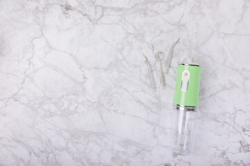 Fototapeta na wymiar Electronic oral irrigator on marble background. Dental tool for oral hygiene. Electric Interdental Cleaner. Dental water shower. Oral care concept. Place for text. copy space.