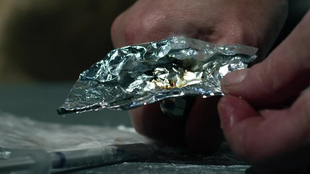Drug addict burning heroin in foil