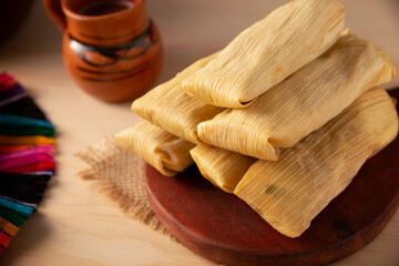 Fototapeta na wymiar Tamales. Prehispanic dish typical of Mexico and some Latin American countries. Corn dough wrapped in corn leaves. The tamales are steamed.