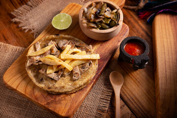 Obraz na płótnie Canvas Beef steak taco with french fries. very popular taco in mexico called taco de bistec or carne asada, homemade roast beef served on a corn tortilla. mexican street food.