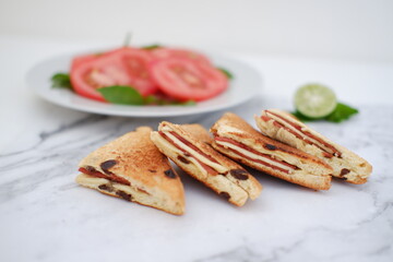 Sandwiches with cheese and cherry tomatoes on a white marble background