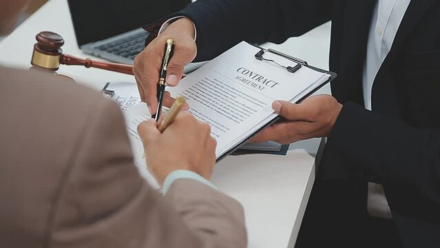 Business and lawyers discussing contract papers with brass scale on desk in office. Law, legal services, advice, justice and law concept picture with film grain effect