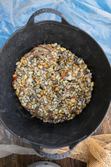 Assorted molluscs in saucepan in wooden boat