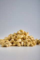 Advertising of healthy snack foods for vegetarians. Raw cashew nuts on a gray background are laid out with a slide to get an appetizing photo.