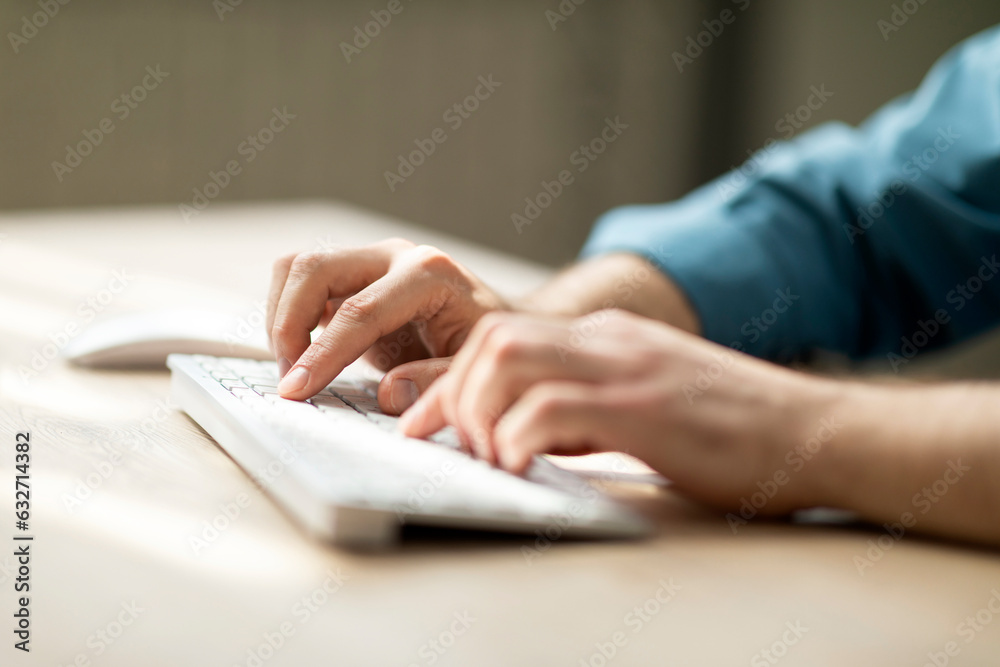 Aufkleber Unrecognizable man typing on computer keyboard while sitting at desk