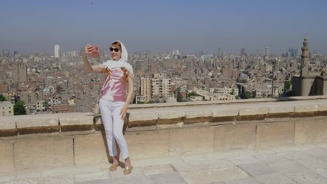 Young adult girl takes a selfie of Egypt city. European woman.