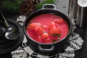 Red borscht soup in bowl.