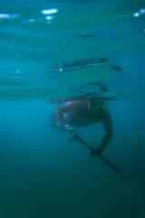 scuba diver spearfishing in the sea blurred background