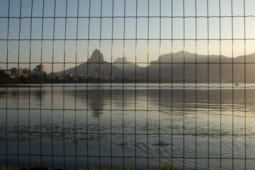Rodrigo de Freitas lagoon  (Lagoa Rodrigo de Freitas) seen from behind the bars during sunset in Rio de Janeiro.