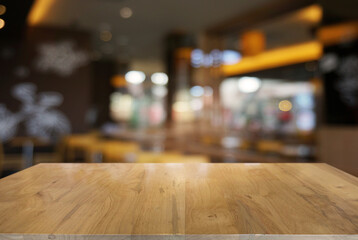 Empty dark wooden table in front of abstract blurred background of cafe and coffee shop interior. can be used for display or montage your products.