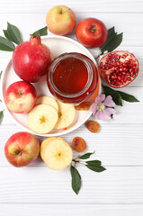 Apples, honey,pomegranate and dried apricots on a bright white wooden background,The concept of the Jewish holiday Rosh Hashanah top view with a place for your text,Jewish New Year and Thanksgiving