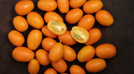 many ripe kumquats on a wooden table