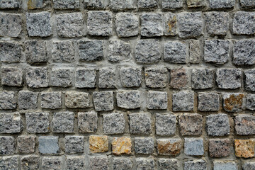 texture of a stone wall made of granite bricks close-up