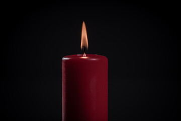 czerwona świeca na ciemnym tle jako symbol pamięci i przemijania - obrazy, fototapety, plakaty