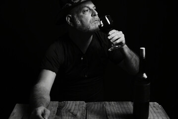sitting man drinking wine face expression black and white photo with silhouette