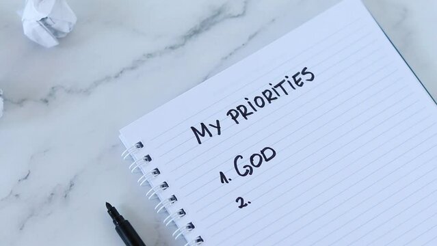 God first, top priorities list, handwritten text on spiral notebook paper. Seek first His Kingdom and righteousness, Matthew 6:33, Christian biblical concept.