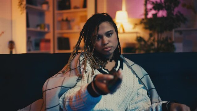 Young woman switching channels and eating popcorn, boring evening, loneliness