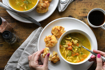 Chicken noodle soup and cheese biscuits on dinner table