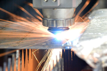 Metal laser cutting. Cutting sheet of metal by laser metal cutting close-up. Industrial equipment machine for cutting metal in factory. Moving head with sparks. Metalwork manufacturing background