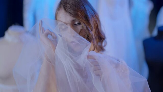 homosexual young man dressed like bride with female hairstyle in fashion atelier, gay man