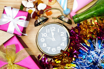 Birthday or holiday party decoration, alarm clock with gift boxes and candy, party hat ana tinsel 