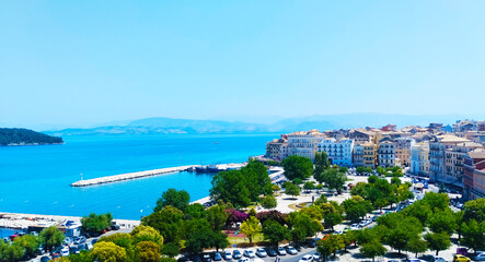 Naklejka premium Island Corfu, Greece, summer 2023. Marina. A lot of sailing boat. Big passenger vessel. View from the fort to the marina. Blue sky and clear water. Very good place for vacation.