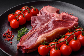 Raw fresh juicy beef t-bone steak with salt, spices and herbs