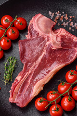 Raw fresh juicy beef t-bone steak with salt, spices and herbs