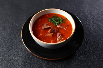 Traditional Russian soup. Cabbage soup - cabbage soup from sauerkraut. Bread croutons.He was lying flat. Black background. Space for copying.