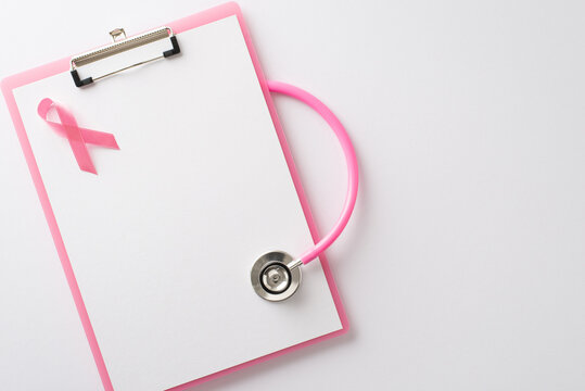 Spreading Breast Cancer Awareness Month message. Overhead shot of pink clipboard and a pink ribbon on a white isolated isolated surface with copyspace suitable for text or promotional materials - Powered by Adobe
