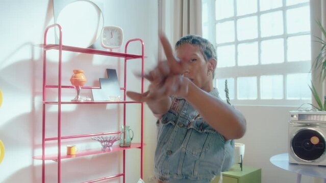 Artistic gender fluid guy with leopard print hair and makeup wearing y2k outfit with visible thong dancing vogue on camera in studio with creatively designed interior