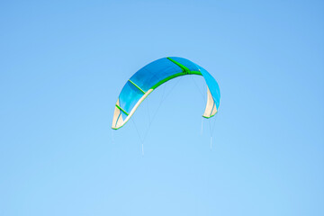 Kite in bright sunlight on a blue sky with white clouds background in summertime