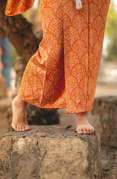 Japanese Tradition And  Beauty: Details Of The Sexy Bare Feet Of A Young Japanese Woman In Traditional Orange Silk Kimono At Serene Japanese Garden