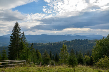 Beautiful view to Carpathian Mountains covered by green forests under cloudy sky, Ukraine