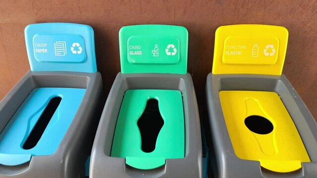 Multicolored plastic trash cans with the inscription paper, glass, plastic for sorting different types of garbage. Plastic bins, garbage cans, recycling. Colored boxes, garbage sorting. Preservation 