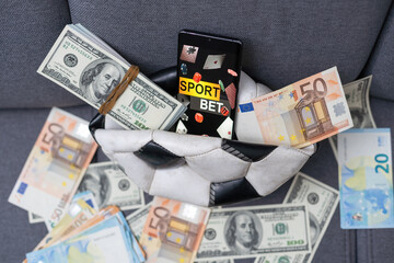 Smartphone with gambling mobile application, ball and money banknotes. Sport and betting concept